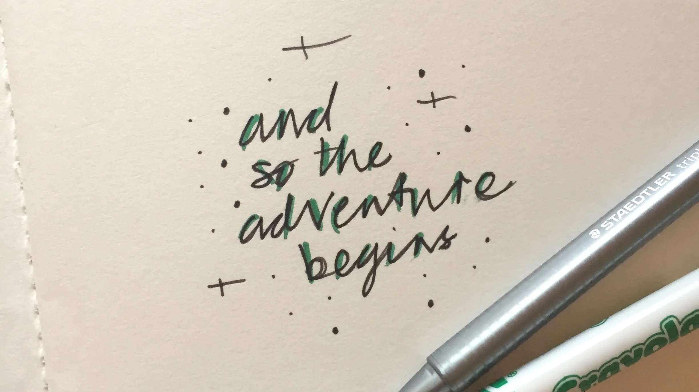 Photo of scribble on paper which reads, 'and so the adventure begins'